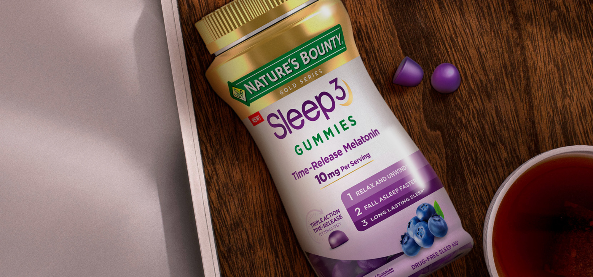 Sleep3 Gummies on nightstand with a cup of tea